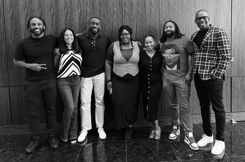 A black and white photo of a group of BlueConic employees posing against a wall.