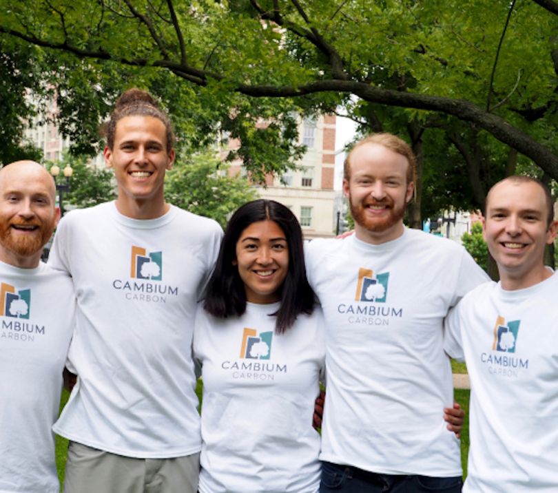 The Cambium Carbon team posing outside wearing t-shirts.