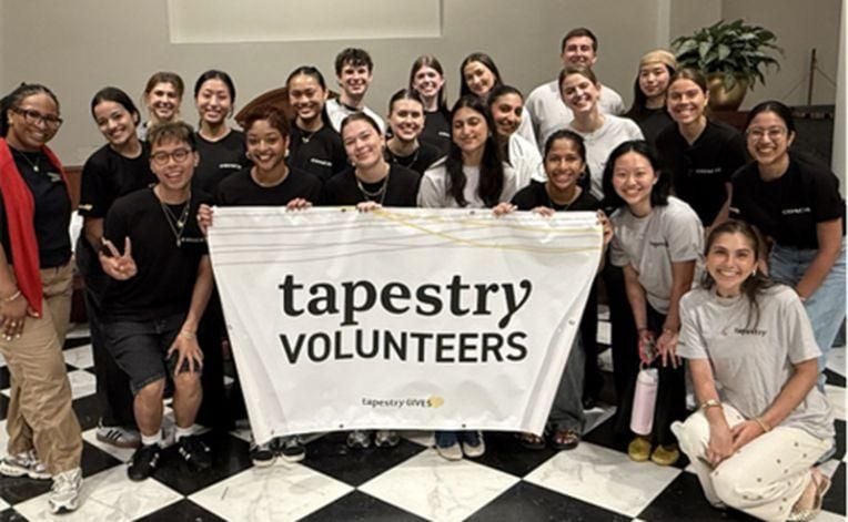 A group of Tapestry interns with a volunteer sign. 