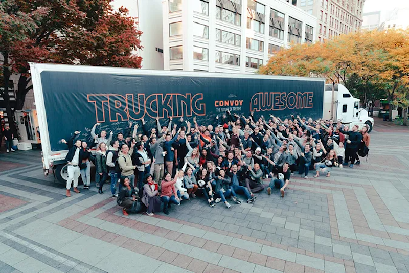 Convoy staff members with a freight truck