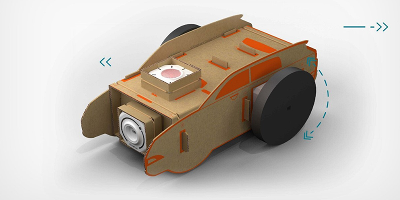 A toy car made from cardboard with Plezmo's IoT sensor attached.