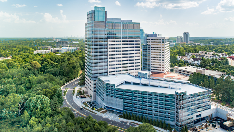 An aerial view of Cox Enterprises' headquarters — a group of large, modern buildings surrounded by green space.