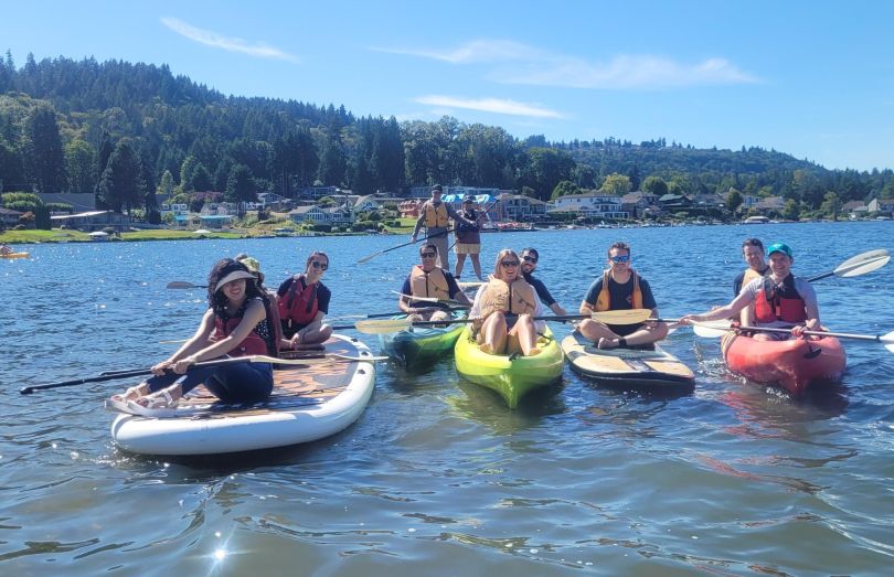 A group of Clean Power Research employees post to take photos of themselves while paddleboarding and kayaking. 