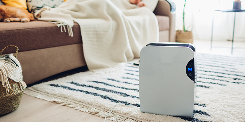 A dehumidifier adjusting the air's humidity as a person sleeps.