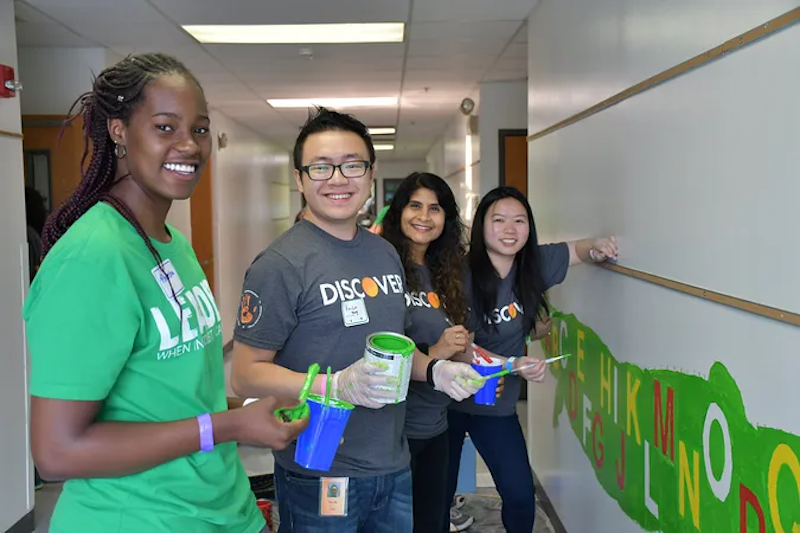 Discover Financial employees painting a mural on a wall