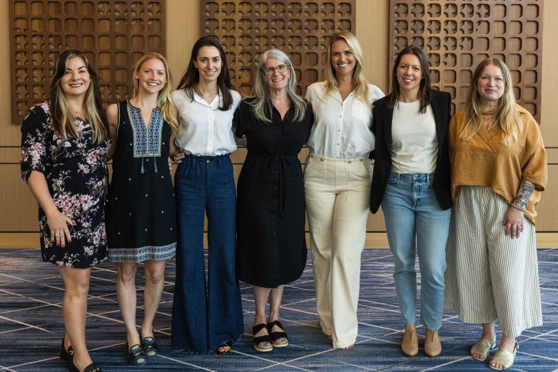 A group of Grow Therapy employees pose with their arms around one another.