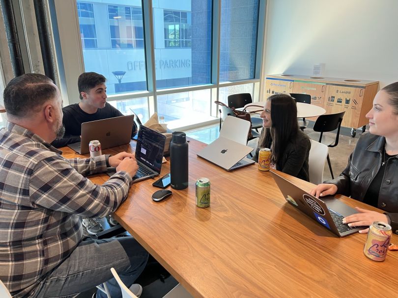 Base team members sit at a table meeting and working together