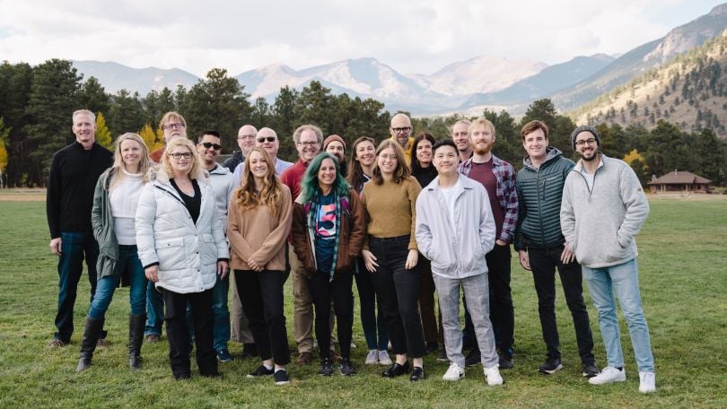 Group photo of InspiringApps team members, with mountains in the background.