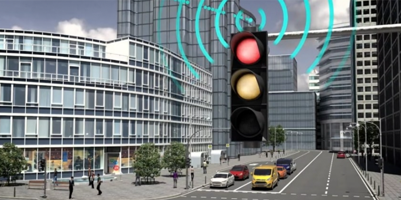 A traffic light IoT device with signals connectivity icons coming out of it.