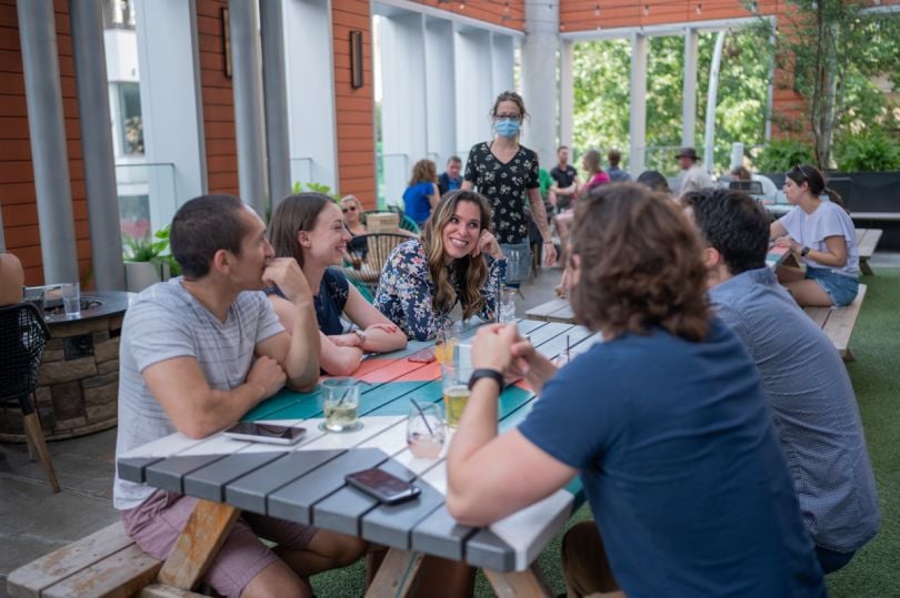 Acrisure team members at a picnic table talking and smiling