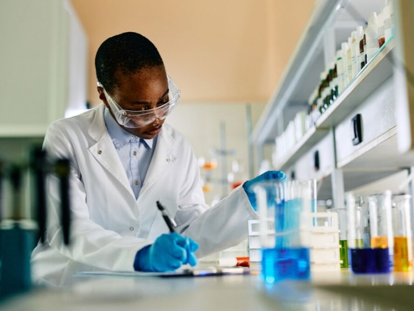 Biochemist taking notes on chemical analysis in laboratory