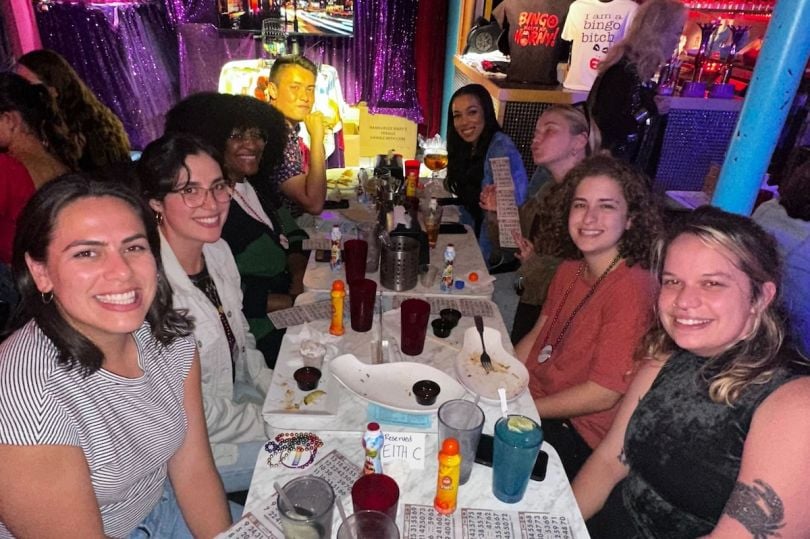 Nowsta team members seated around a table at a company happy hour. 