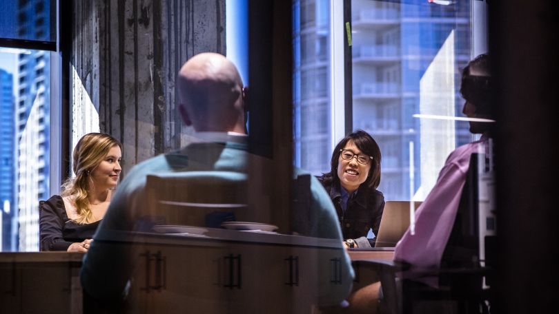  Team members gather around a conference table.