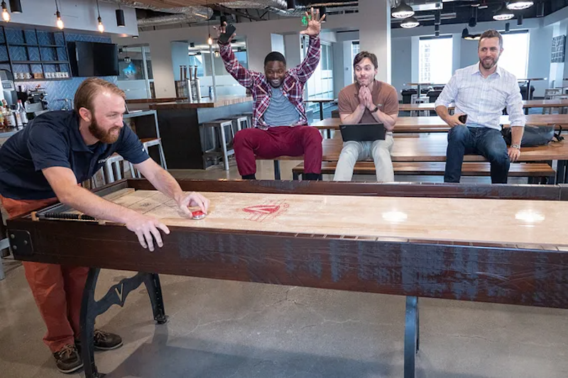 PitchBook employees playing indoor shuffleboard