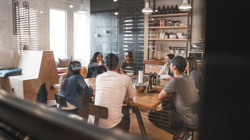 Unsplash photo: looking through glass at a team meeting