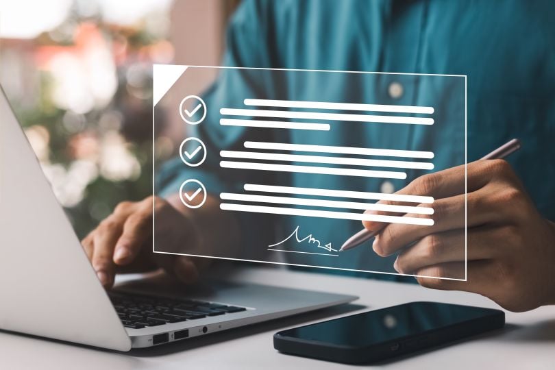 A person signing a digital document, symbolizing electronic agreement or verification.