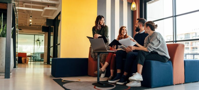 Team members chat over a laptop.