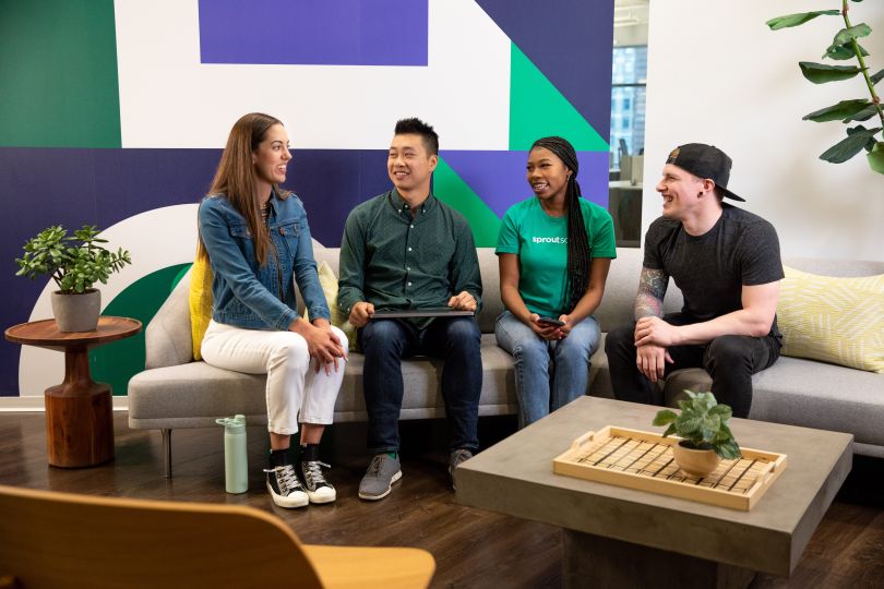 four sprout social colleagues sitting together on a couch in the office