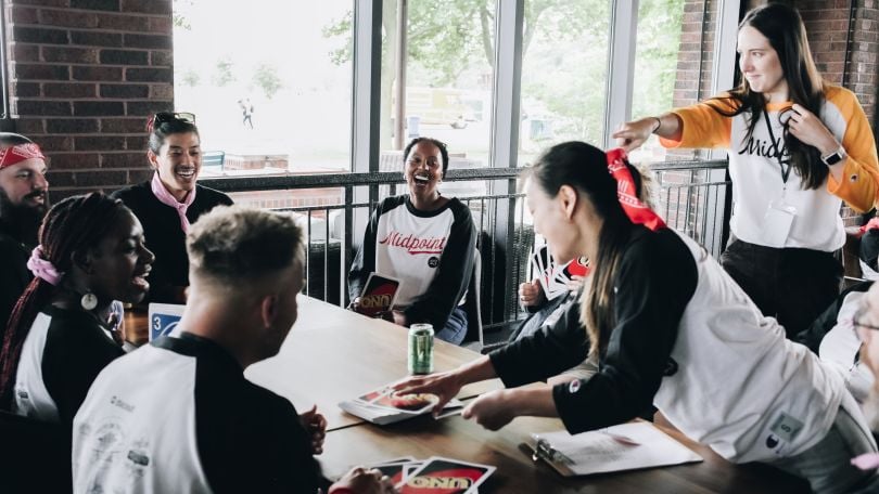 At dscout’s Midpoint team gathering, a group plays Uno with giant cards while laughing.