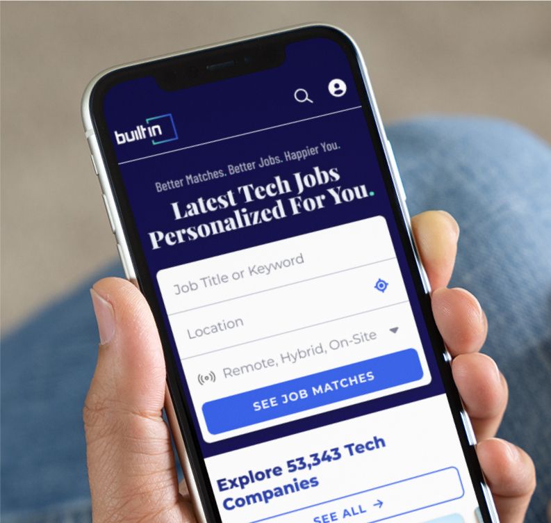 Hand holding mobile phone, on the screen is the Built In site, reading “Latest Tech Jobs Personalized for You.” 
