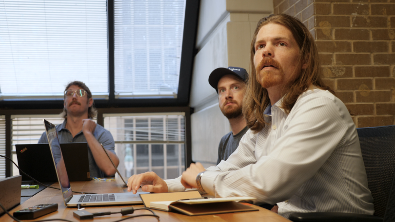 Unchained team members watching presentation together in the office. 