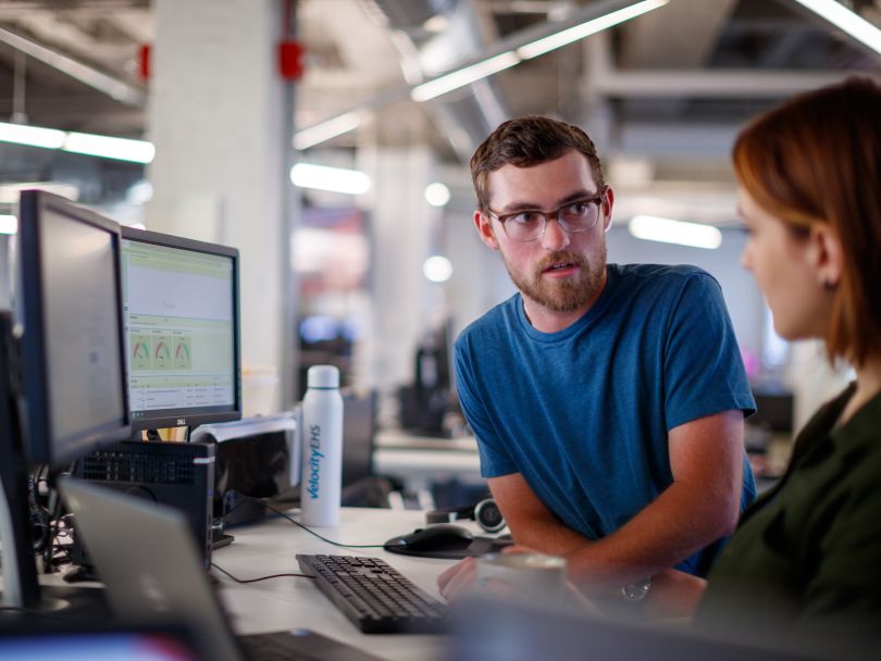 Two VelocityEHS team members working together at a computer