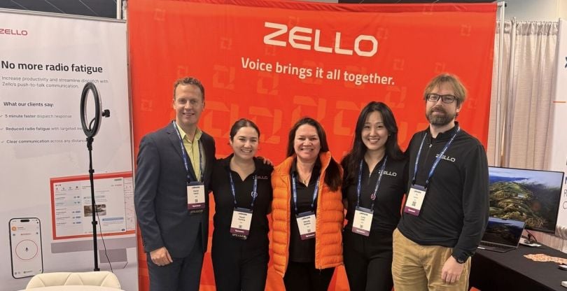 Zello team members pose at a conference booth.