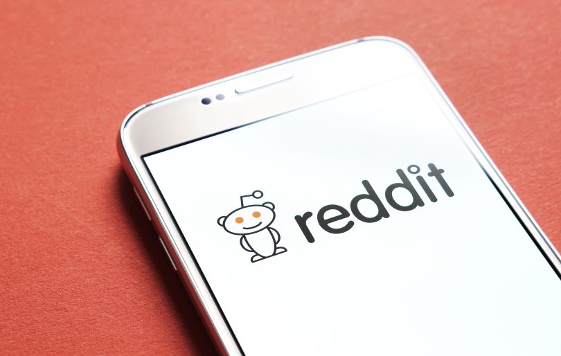 The Reddit logo on a phone screen is pictured.