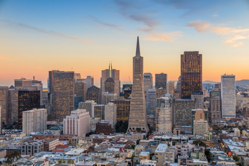 The sun sets over the San Francisco skyline.