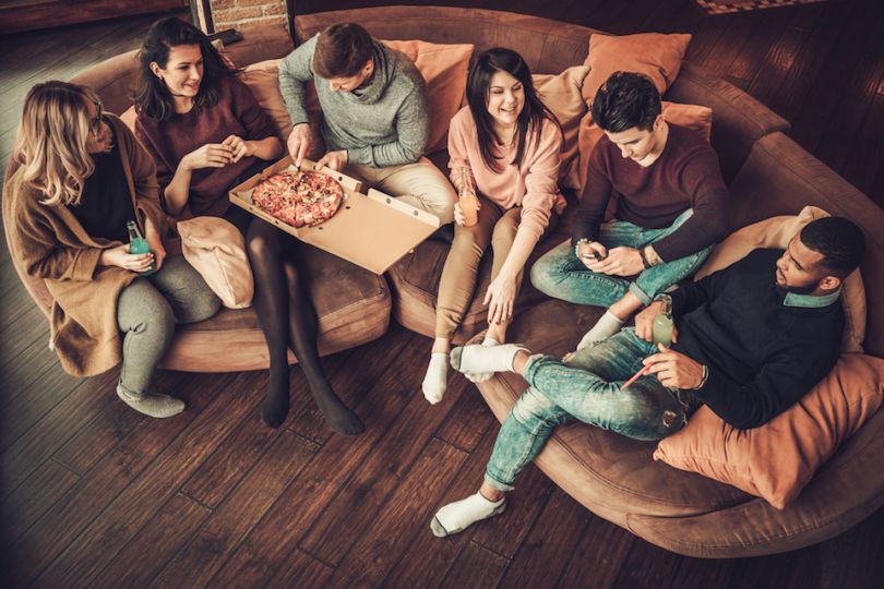 College students eating pizza on a couch - GrubHub