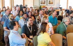 an audience of employees laughs during a company-offsite