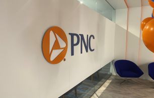 The inside of a PNC office building, showing the PNC logo on a wall