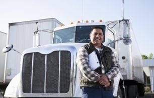 Man smiling in front of a truck.