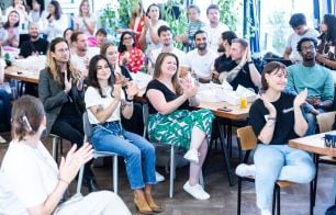 Group of employees clapping and watching a presentation