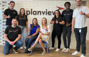 This is a group shot of some of out team members celebrating pride in their pride shirts and with their pride flags. 