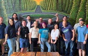 Acoustic employees in front of a colorful mural