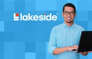 Smiling tech professional with a laptop next to Lakeside Software logo