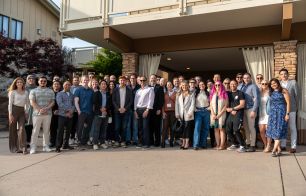 A group of 50+ employees pose in front of a building