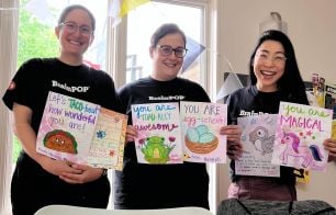 Three employees displaying handmade cards made during Global Day of Service 2025