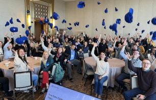 Securly team celebratign by throwing blue ball caps in the air