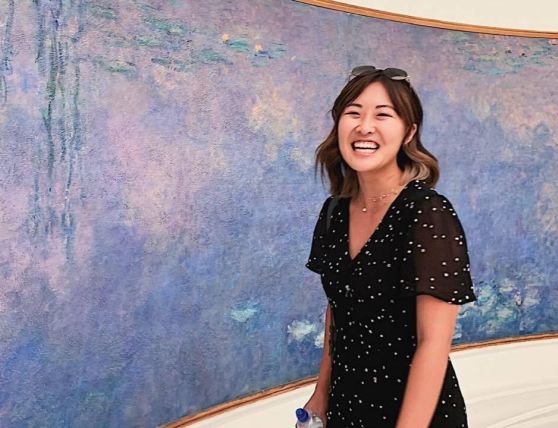 Photo of Tori Park laughing next to a large painting